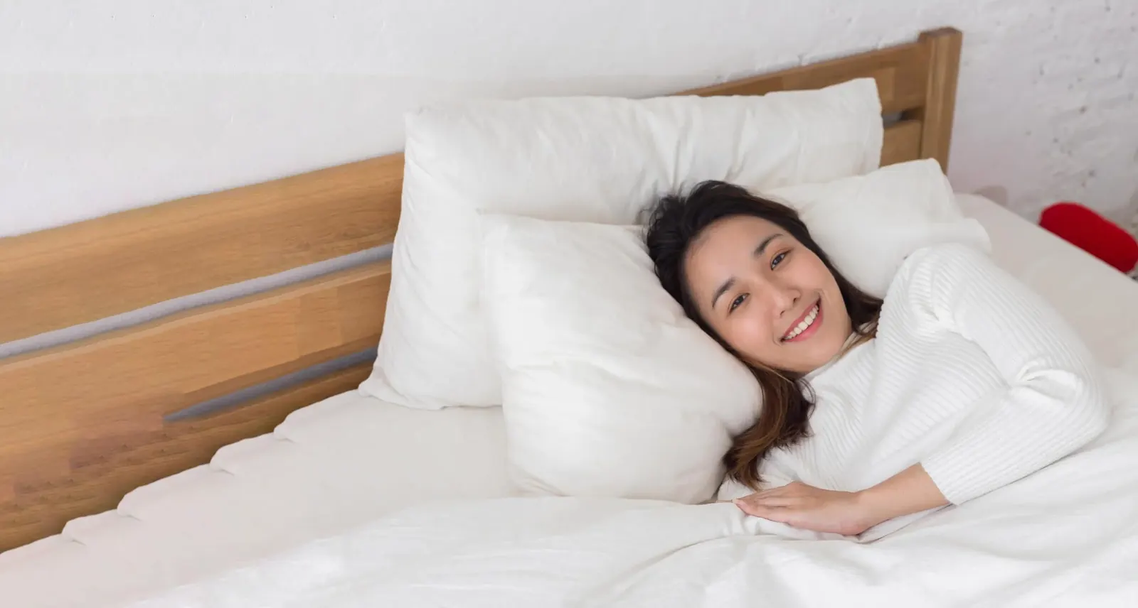 Smiling woman relaxing in bed after a good night's sleep on an MBF mattress
